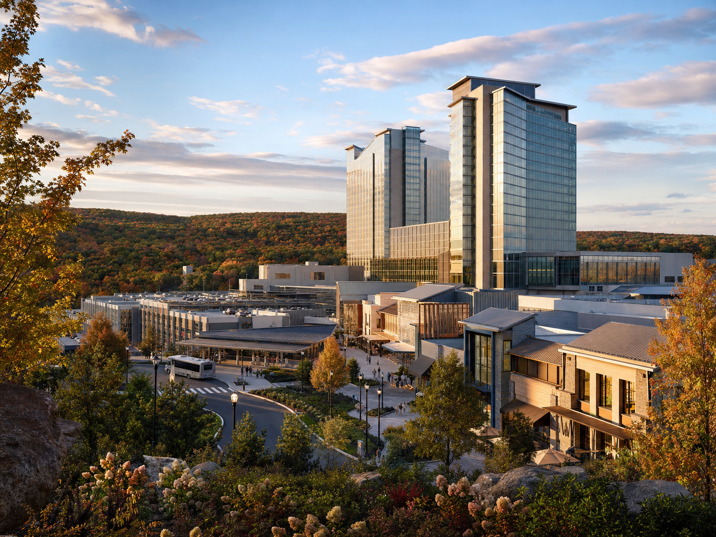 A wooded Northeast resort campus with hotel towers and evening pathway lighting.